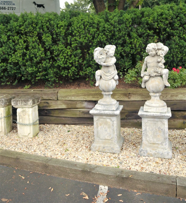 Cast stone putti depicting the flora of summer and the abundant harvest of fall, atop Classic paneled pedestals.
 