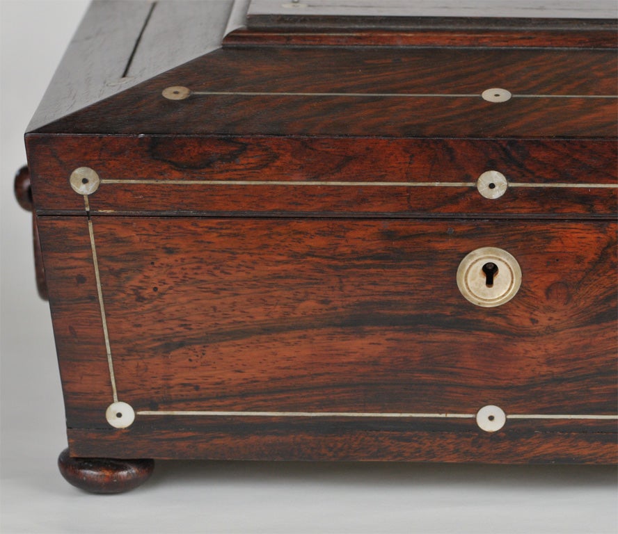 Beautiful rosewood sewing box with mother of pearl inlaid, circa 1820, has blue silk interior and looped handles on both sides. Totally restored inside.  The top insert pulls out.