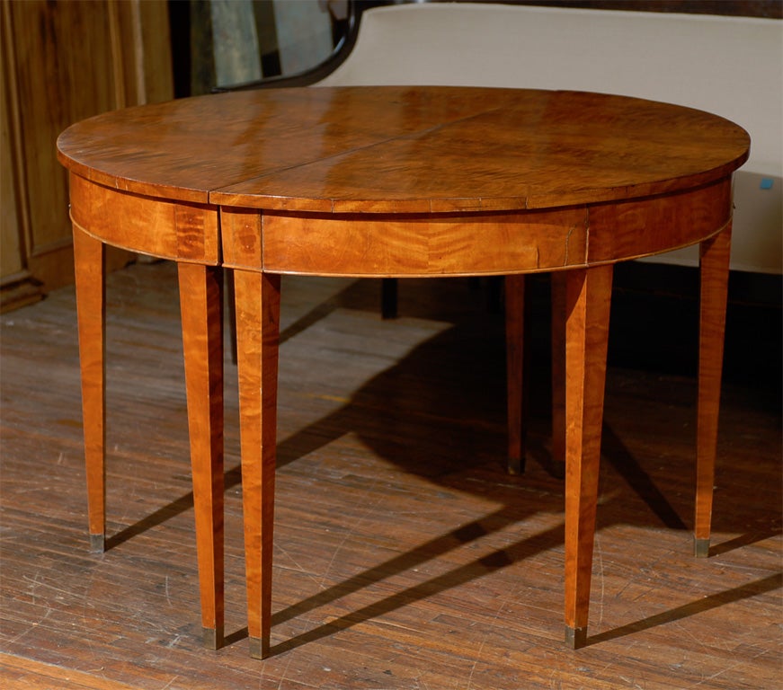 A Karl Johan style Swedish birch table with one leaf. The table is round without the leaf and becomes oval with the addition. The Karl Johan period follow the Gustavian period in Sweden.