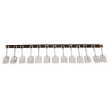 White Sandshovels Suspended from Wooden Rack with Iron Hasps