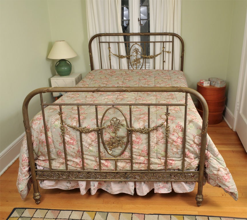 This French bed is loaded with detail.   The edges are trimmed with brass frowers.   The design on the legs are varied and interesting.   Both the headboard and the bottom board have the original bevelled glass.  There is a floral design on each