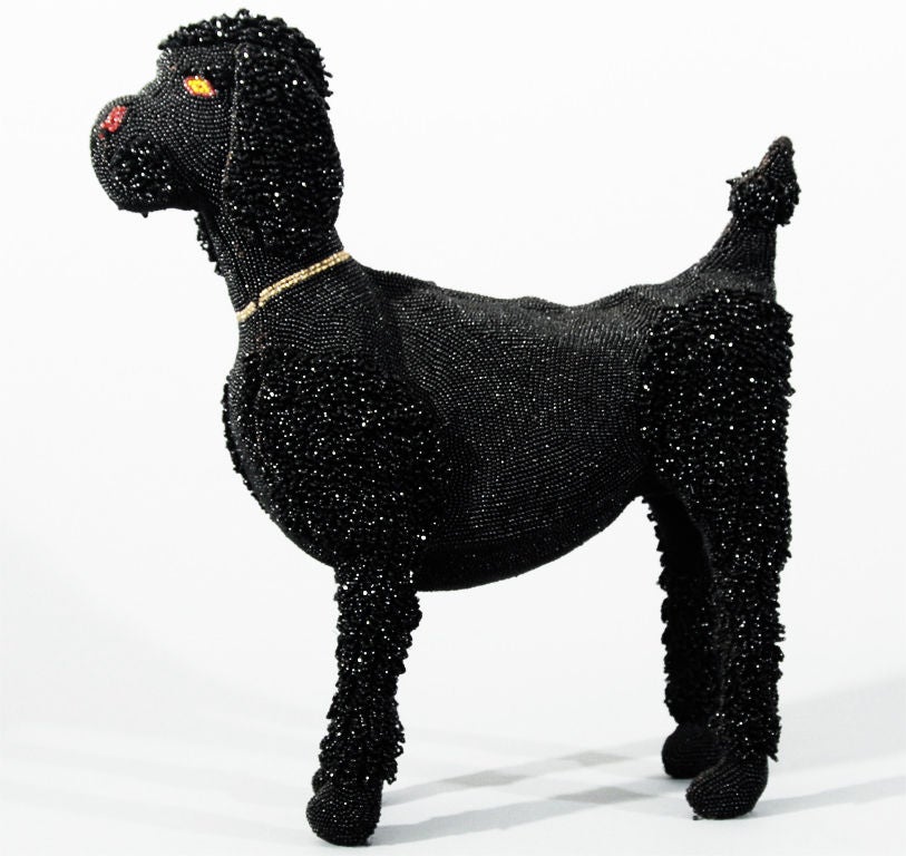 This rare Walborg hand-beaded black poodle purse was made in Belgium, circa 1940. It has a red nose, yellow eyes and a gold collar.  A zipper closure runs along the top of the back. The ears and poufs are are composed of smooth beads alternating