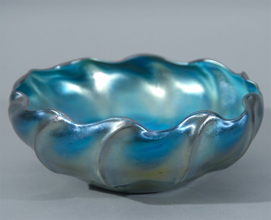 A handsome Tiffany blue iridescent Favrile glass bowl with a lobed body and waved rim.