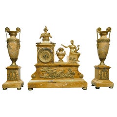 AN EMPIRE STYLE CLOCK GARNITURE. FRENCH, C. 1880 AN EMPIRE STYLE CLOCK GARNITURE. FRENCH, C. 1880
