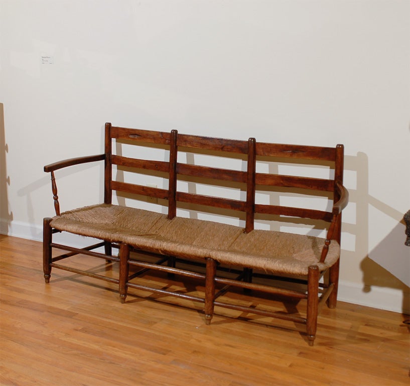 This is a handsome French bench with a rush seat.  The bench sits three.  The patina is lovely.  The wood is fruitwood.<br />
<br />
Please visit our website for more pieces.<br />
www.dearingantiques.com<br />
Dearing Antiques was established
