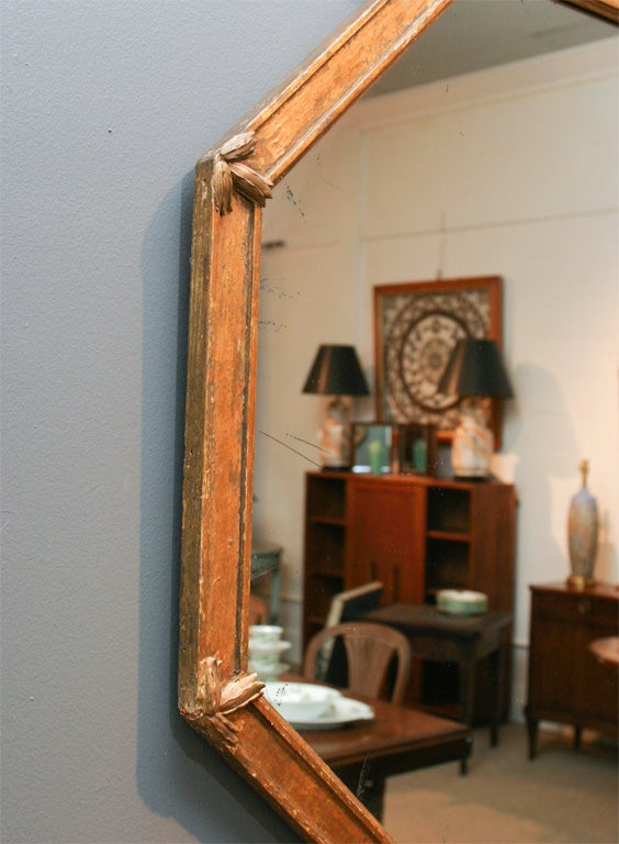 A wonderful Regency style gilded octagonal mirror with a laurel leaf and ribbon pediment.