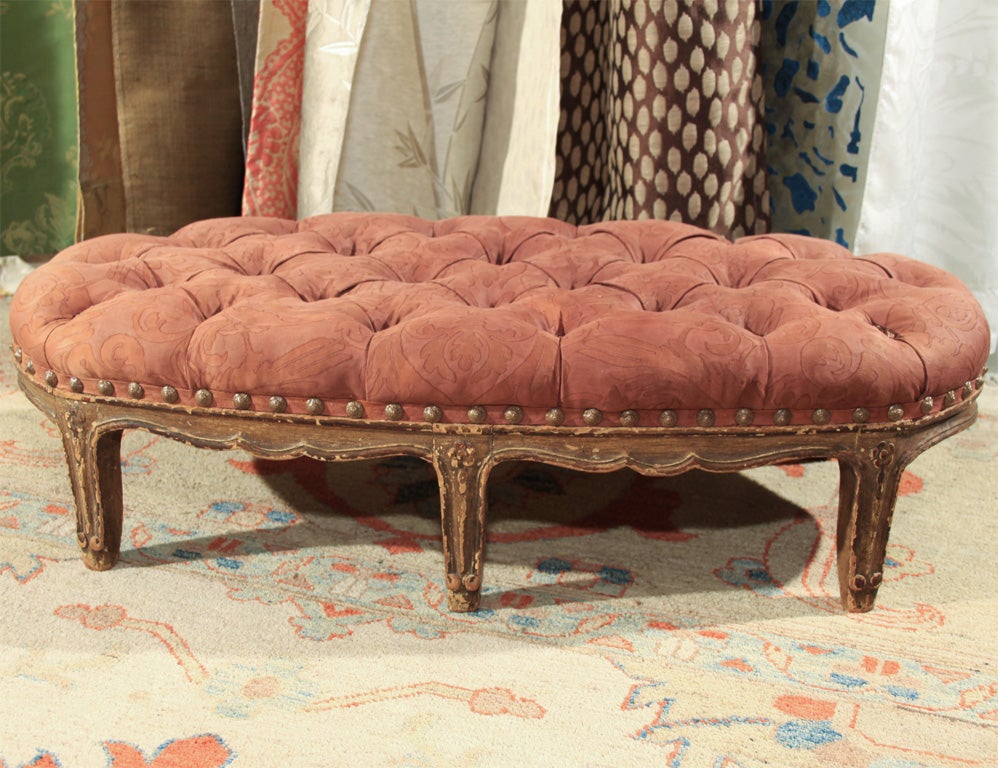 Very charming tufted stool with Antique Fortuny fabric.  The tufts have silk poms instead of buttons and the base trim has French nails.