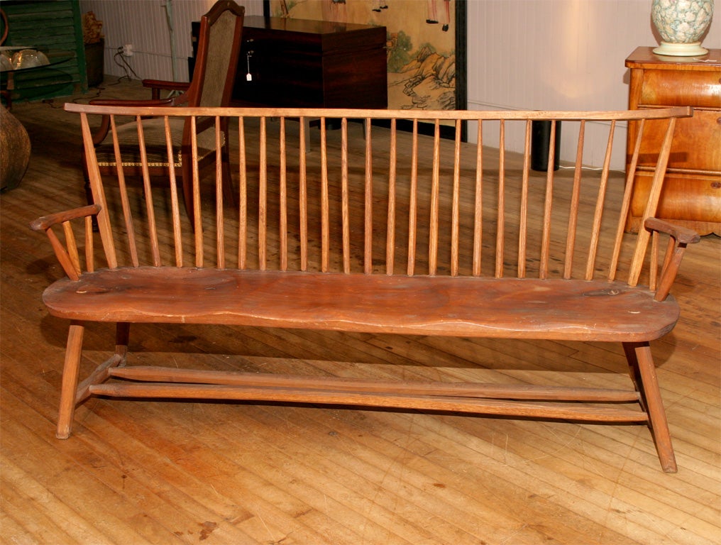 beautifully designed windsor style bench by Hunt<br />
one board pine seat<br />
hand plained spindles, legs, and stretchers<br />
 top rail curves at each end<br />
steps down to curved arms<br />
dry untouched surface
