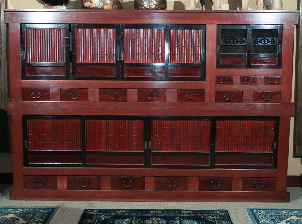 Japanese massive kyushaku mizuya, kitchen pantry storage chest from the Kyoto area. Originally used in a large residence or traditional inn. The two sectional chest of keyaki (zelkova) wood for the  door panels and drawers and sugi (crypotomeria)