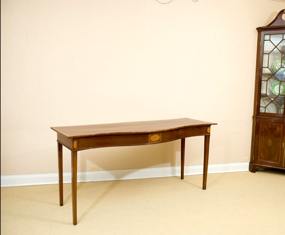 Very fine antique Irish Georgian serpentine shaped Serving Table in figured mahogany, inlaid with satinwood and olivewood. Raised on square tapering legs.