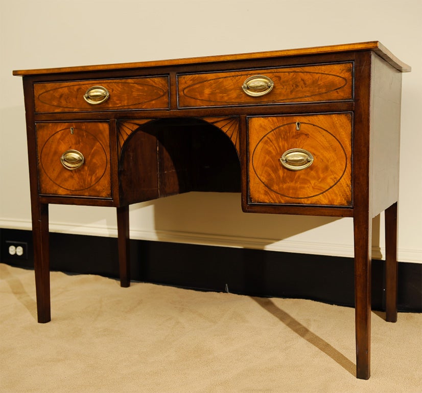 This fine example of American Hepplewhite furniture was originally intended as a dressing table, but has done duty over the years as a desk (ink stains in drawers). Original inlay.  Restored French polish.<br />
Originally priced at $3400.00