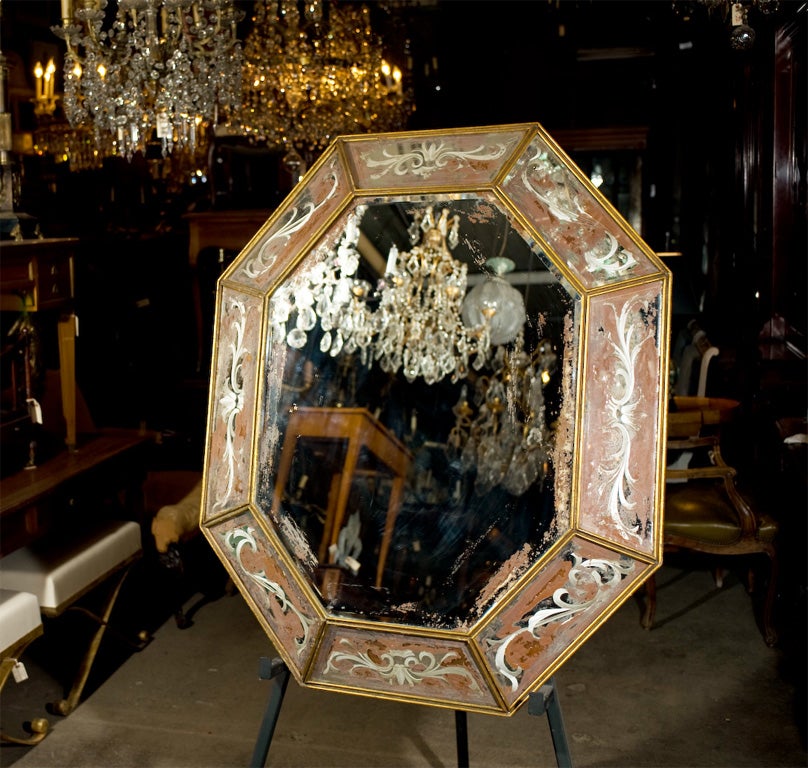Beautiful octagonal form cushion mirror framed with sections of reverse painted mirror set into simple giltwood framework. Mirror is beautifully distressed.