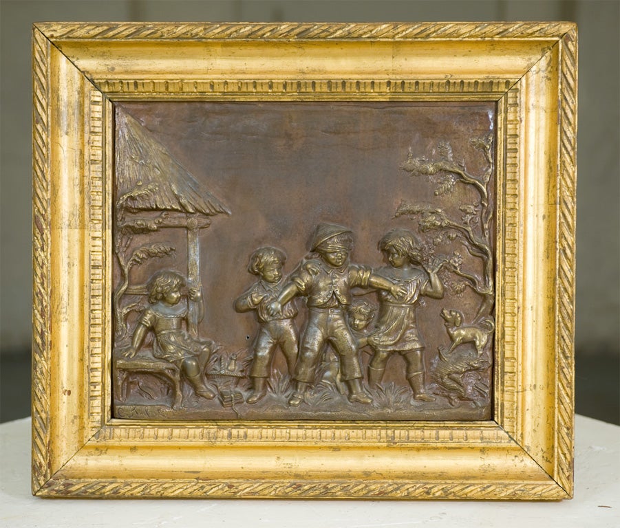 Pair of patinated zinc relief panels depicting children at play, both framed in matching hand carved gilt frames.