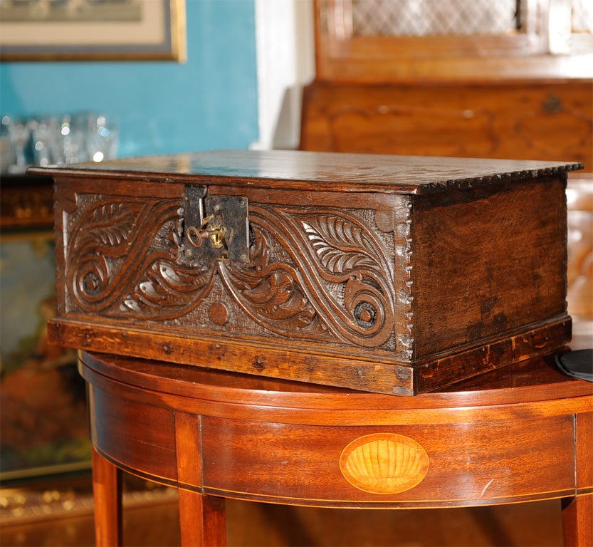 A finely carved oak lift top Jacobean English document box, carved lid and body with original iron work.
