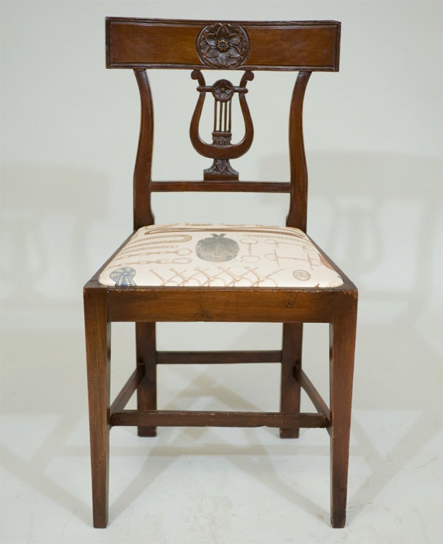 A pair of Italian late 18th-early 19th century walnut hall chairs

with lyre shaped carved backs.