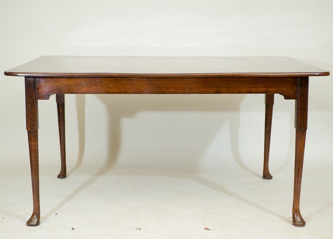 An English Queen Anne period red walnut dining table

raised on pad feet.