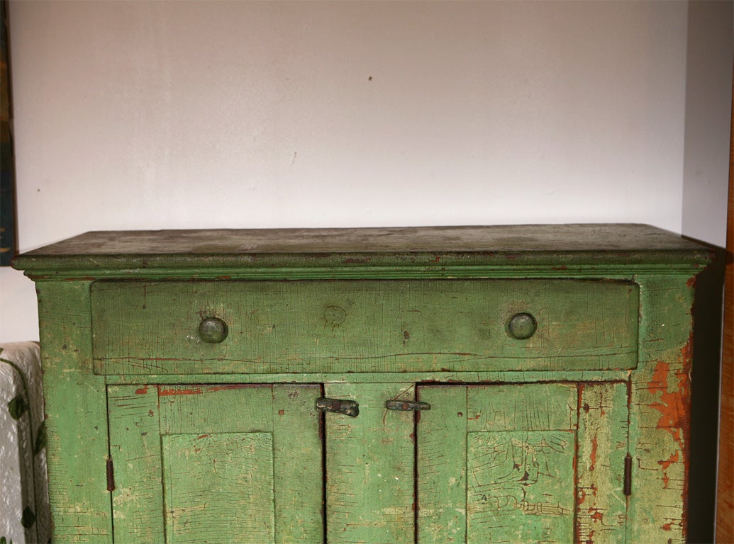 19THC ORIGINAL GREEN PAINTED JELLY CUPBOARD,ONE DRAWER OVER TWO DOOR.GREAT OLD SURFACE AND SQUARE NAIL CONSTRUCTION.WONDERFUL DUSTY ROSE PAINTED INTERIOR.THE EXTERIOR HAS A CRACKLE ALIGATOR SURFACE FROM AGE.THE CONDITION IS GOOD.THIS PIECE COMES