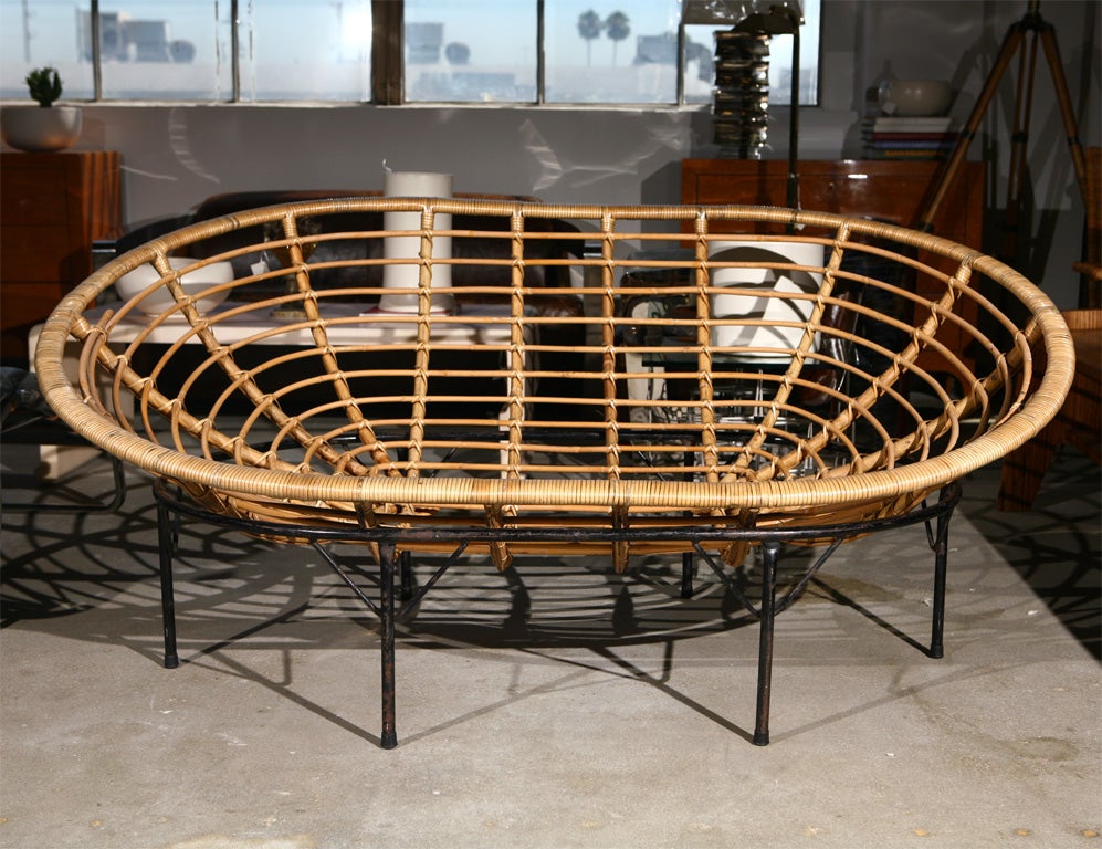 Faux rattan oval lounge chair on black painted metal stand