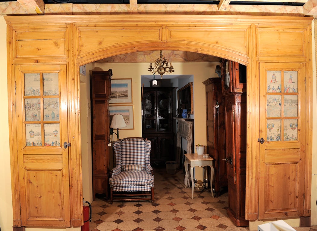 This architectural Wood Archway features two Side doors with glass panes. The doors are outfitted with iron hardware.<br />
Dresses beaurifully any large door opening,