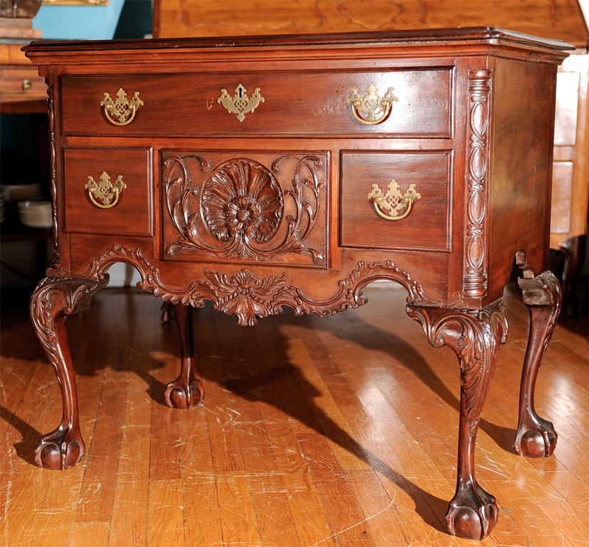 A Philadelphia Chippendale style mahogany lowboy, one long drawer over three center drawers, the center drawer having a finely carved shell, finely carved apron and skirt, four richly carved cabriole legs, acanthus leaf at the hip terminating in