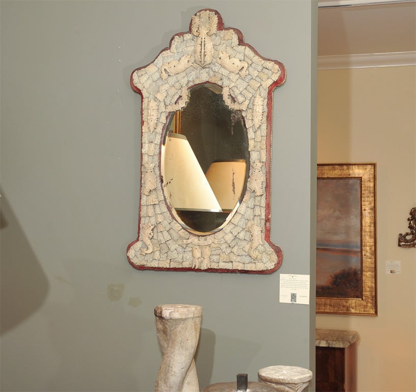 Mid 19th Century British Dieppe Mirror Composed of Hand Carved Overlapping Ivory Leaves, the Surface then Decorated with Mythological Figures, Stylized Shields and Dolphins with Crowns, the Original Oval Beveled Mirror Plate with Antique Crimson