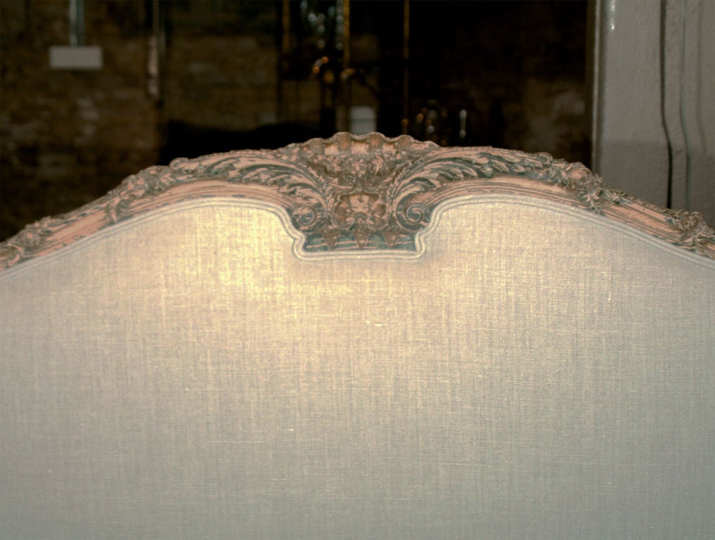Carved wing headboard with original finish. Reupholstered in fog Belgian linen. Full size.