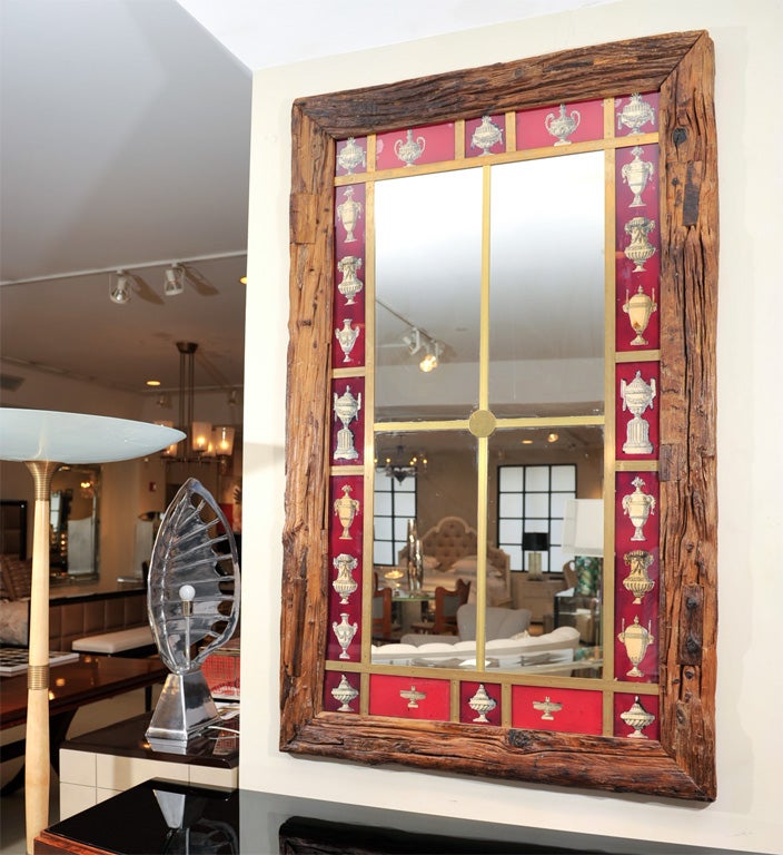 Rough hewn reclaimed wood with red églomisé bordered mirror and brass crossbar detail.