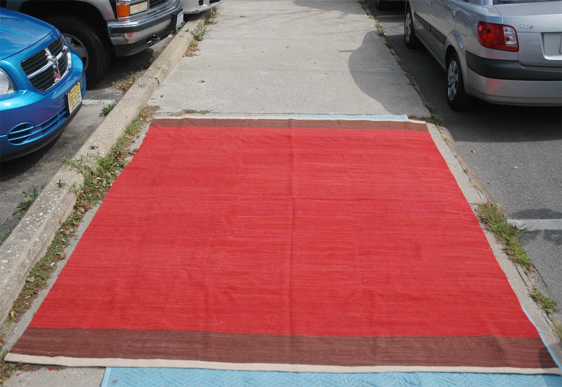 Graphic red flatweave rug with a brown and ivory stripe at either end