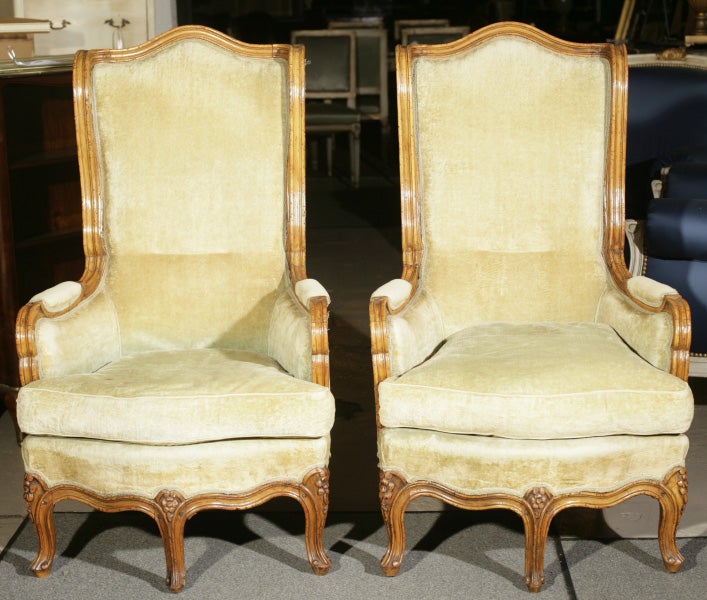 Pair of French Provincial armchairs with five legs. Louis XV style with three legs in the front. Light fruitwood with velvet upholstery. Hand-carved. Can sell separately.