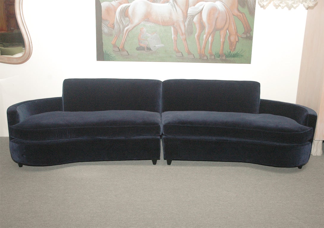 This stunning and sexy two piece Hollywood Regency sofa, has separate sprung seat cushions and has been newly reupholstered in a beautiful midnight blue velevt fabric