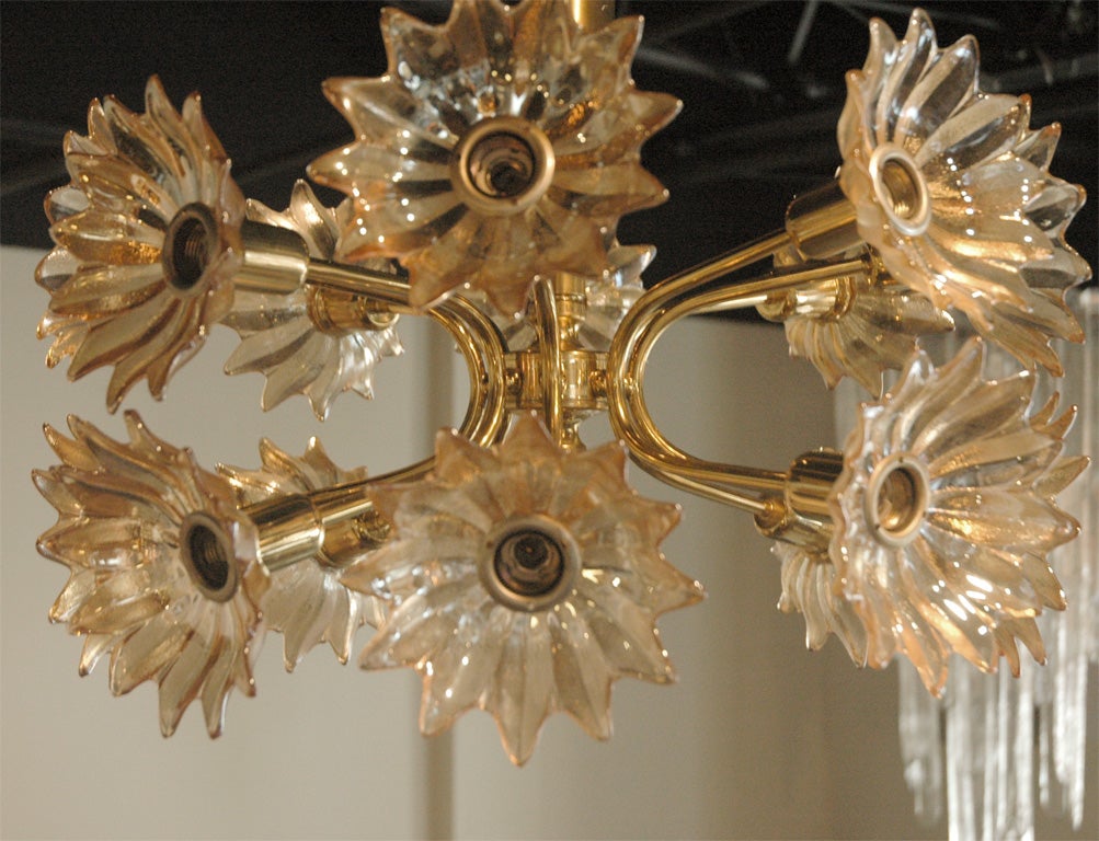 Great brass sputnik style chandelier with glass flower elements with gold tones and sixteen light sources.