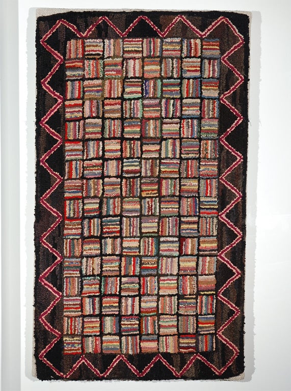 Rare miniature log cabin hand hooked rug with great zig zag border. Professionally mounted on linen and stretched frame. Wonderful multi colors on black ground. The condition is mint and scale is small.