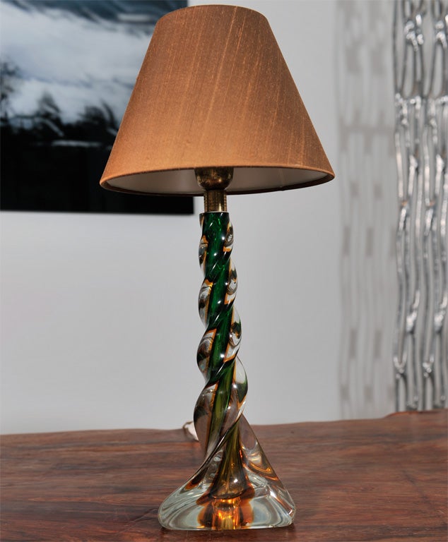 With a swirl of amber and green at it's core this little table lamp has a modern 1970s vibe. The shade is new.