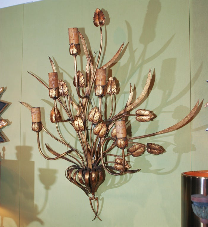 Gilded hand cut metal, leaves cascade out from a center medallion with 5 arms in the form of stems and tulips.