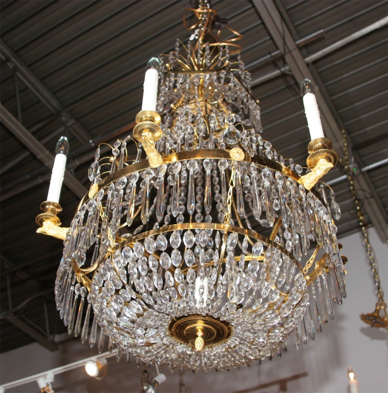 A six light crystal and ormulu Baltic chandelier having a central light with eagle head candle supports; the upper tier is starburst of ormulu with cascading crystal drops - formerly from the estate of Ariane Dandois.