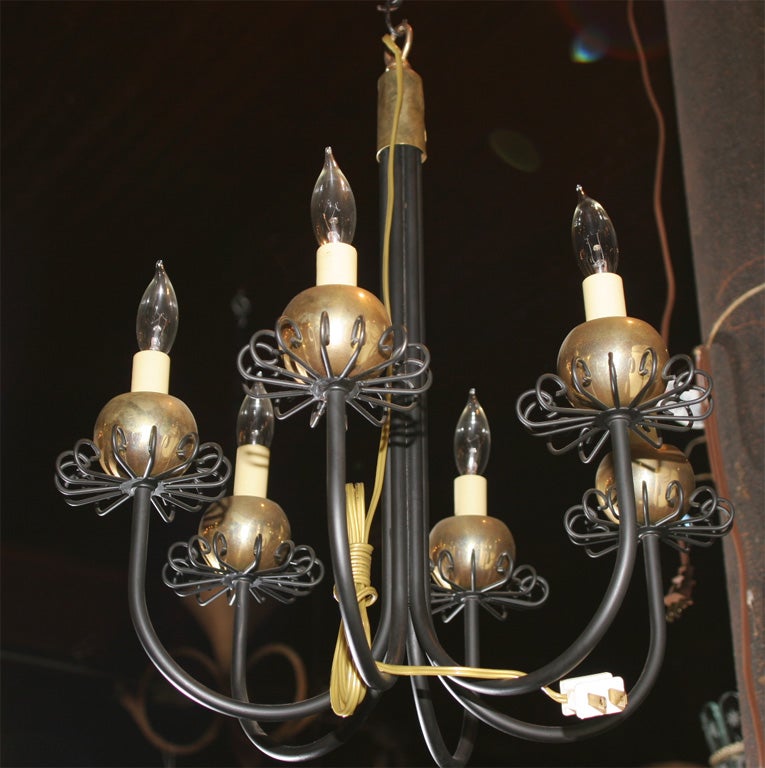 Pair small six-arm black metal and brass chandelier featuring brass ball and curlicue bobeches. Priced individually.