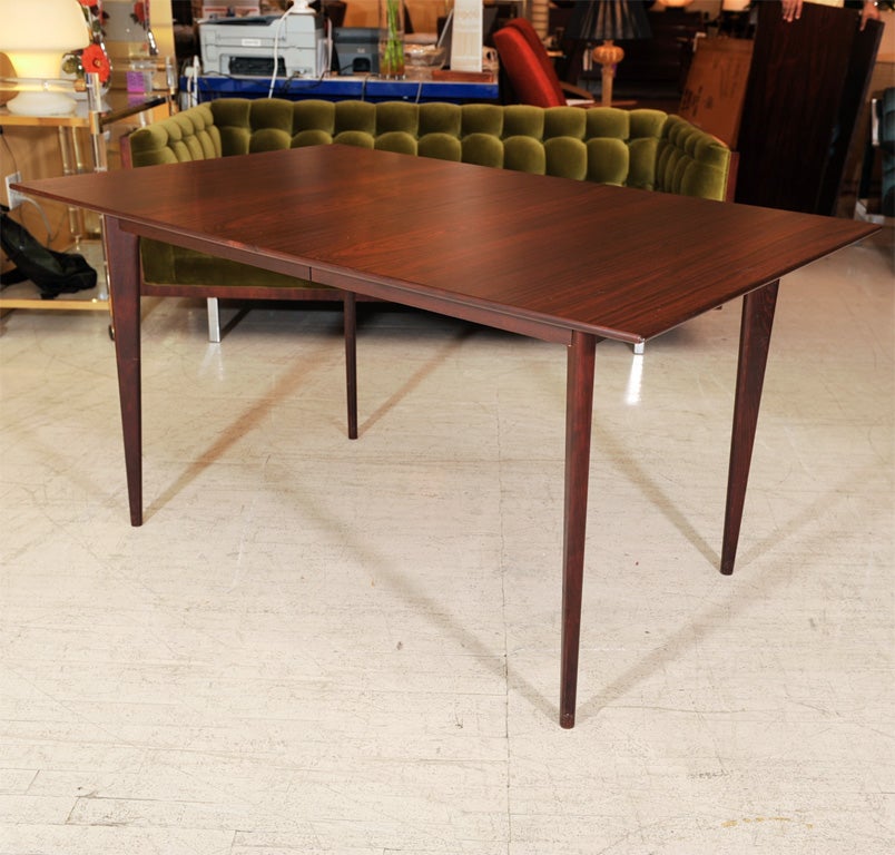 Beautiful rosewood dining table with two extensions. Crisp, clean design with beautiful graining. Each extension measures 16
