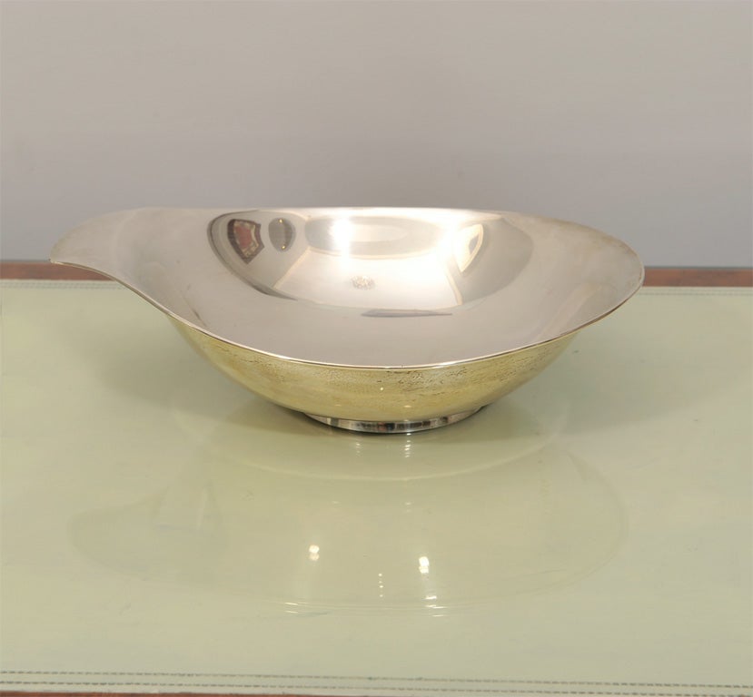 This sophisticated and sculptural sterling silver bowl was hand-wrought by Allan Adler in the 1950s, one of America's most esteemed silversmiths of the era. It offers an organically shaped circular form with an elegantly curved lip and smooth