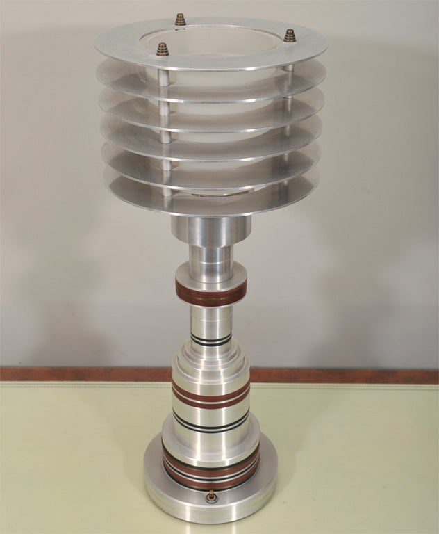 This rare lamp exemplifies the Art Deco Machine age era in America.This lamp is brushed aluminium,glass(which is original)and bakelite. This piece is documented in every book that has the best of American Art Deco.