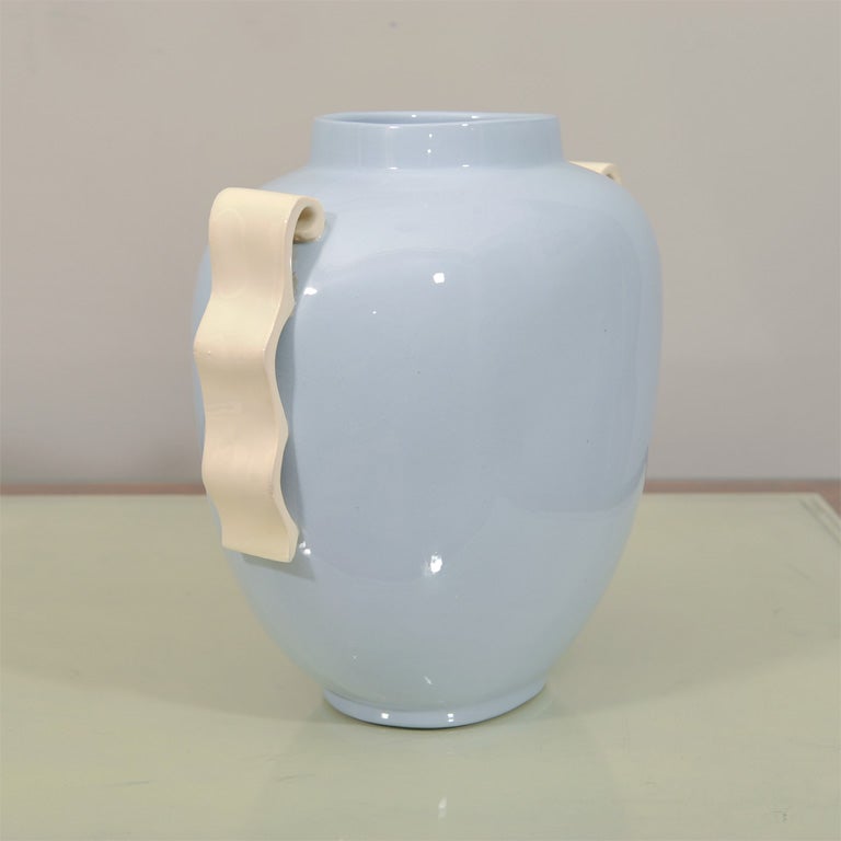 This stunning vase is based upon an ancient Greek Amphora interpreted in an Art Deco Neoclassical manner.The curved handles rest upon the stunning blue glazed body of the vase.