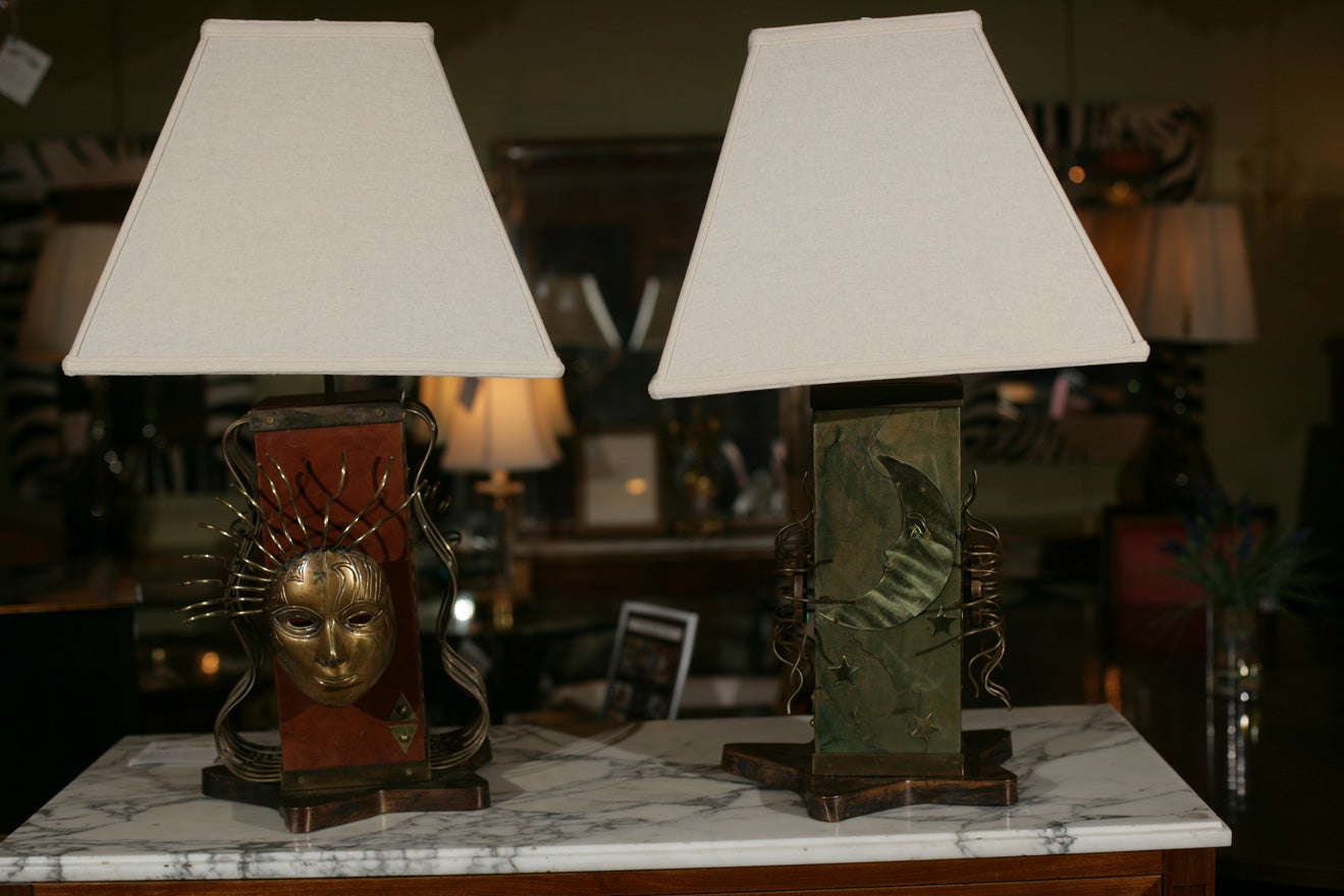 Pair of Italian modernist brass decorated and leather embossed pedestal lamps, on star-form base and mask decoration. With original shades.