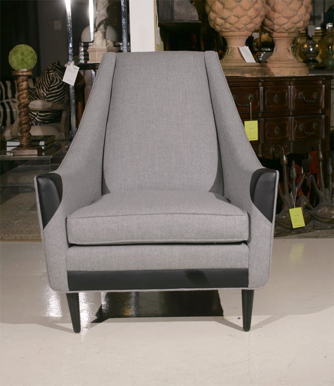 Handsome arm chair in gray flannel and leather accents.  Simple peg leg.  Very comfortable
