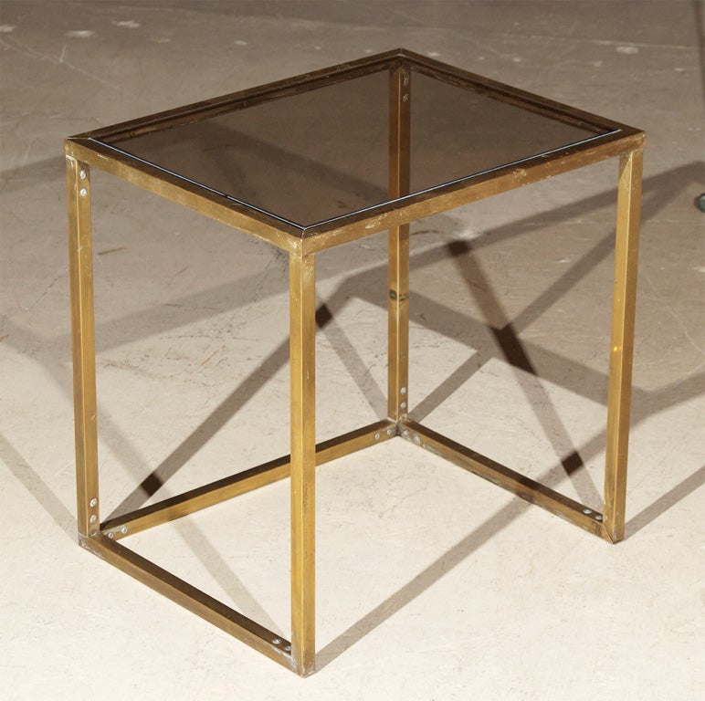 Set of 3 tables made of brass with bronze-colored glass tops.  The smallest table has a mirrored bottom.  Dimensions given are for largest table.