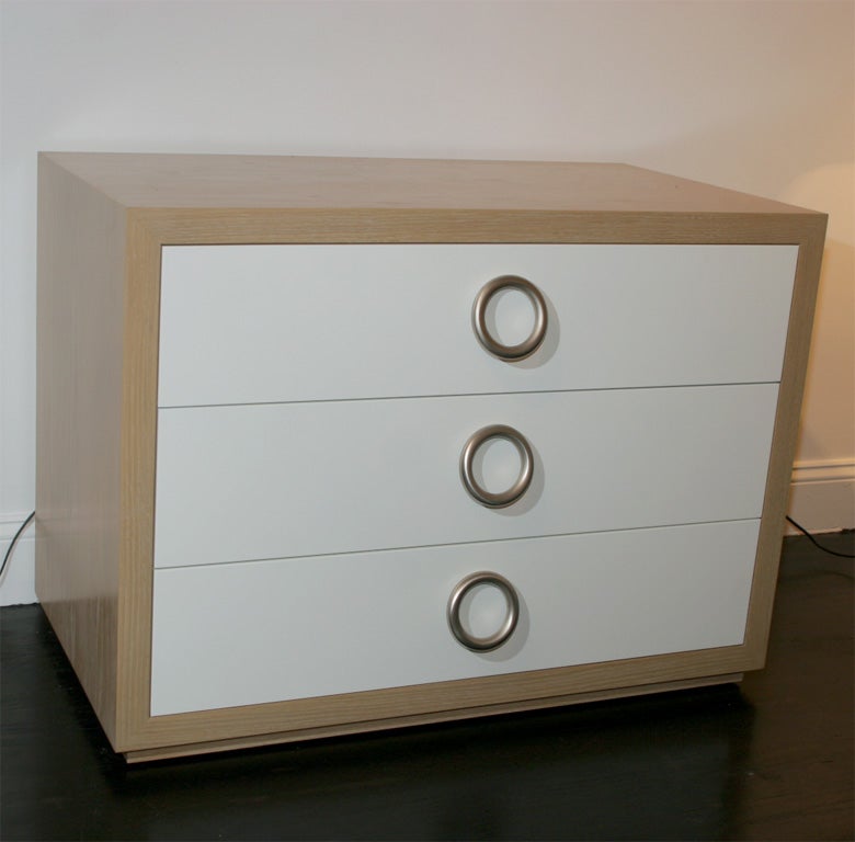 High-polished piano lacquer and cerused oak chest of drawers featuring three drawers and distinctive oversized brushed nickel pulls. Set on a recessed oak base.