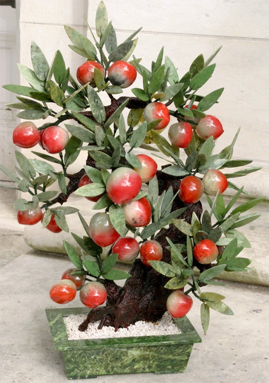 A large Bonsei Peach Tree made of Hard stones. The container in veragated green jade and the leaves in nyphrite and veragated soapstone to give the leaves a more natural appearance all set in place with natural white marble chips. The peaches are in