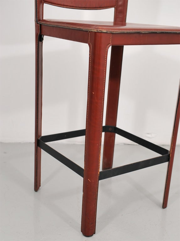 Stool in the style of Jacques Adnet. The leather is sewn over a steel frame.