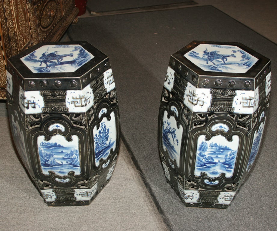 Pair of 1920's Chinese blue and black porcelain stools with landscape decoration in blues.