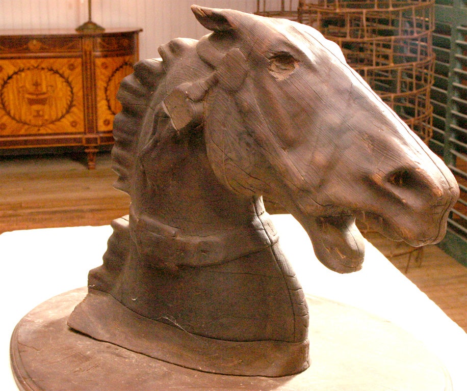 carving of a horse head in pose of fiery exertion<br />
harness with open mouth<br />
dry blackened pine surface<br />
allegedly hung in a blacksmith shop in Pine Plains, NY
