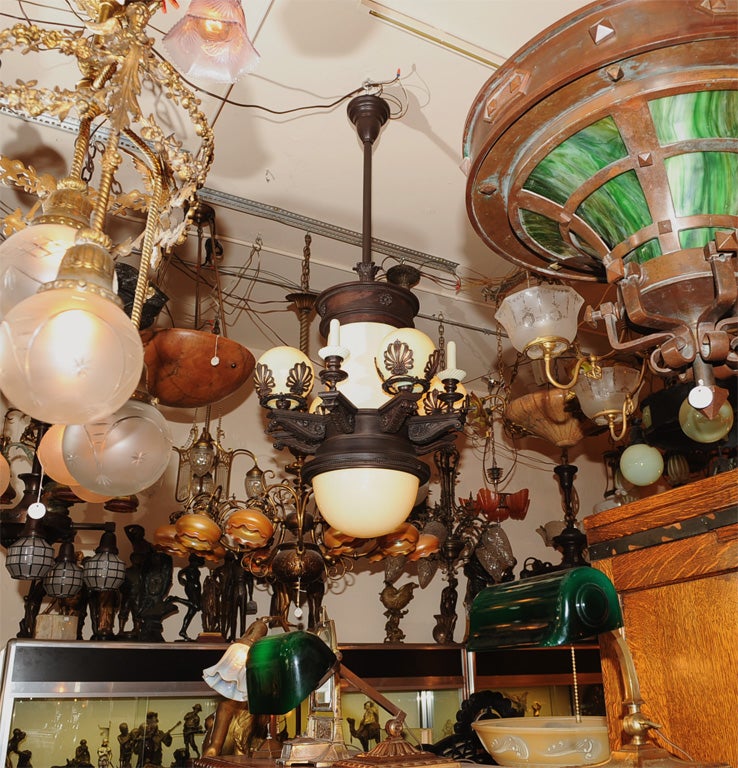 Museum quality American late Victorian gas and electric chandelier. The vaseline glass is all original and the patina is superb. It has five vaseline balls that light up; the center bottom globe takes two light bulbs; the center shaft also takes two