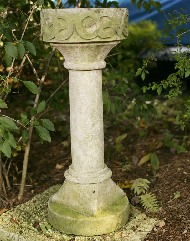 A limestone birdbath, the body of the bowl decorated with a band of Celtic knots.